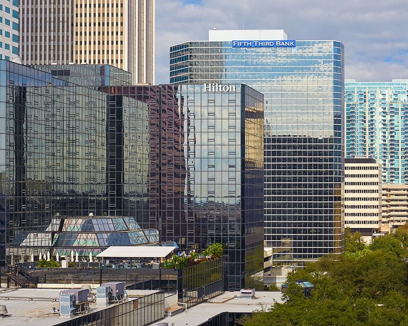 hilton-hotel-and-fifth-third-bank-cityscape-downtown-sita. Cityscape view of the Hilton Hotel and Fifth Third Bank high-rise buildings in a downtown commercial district.