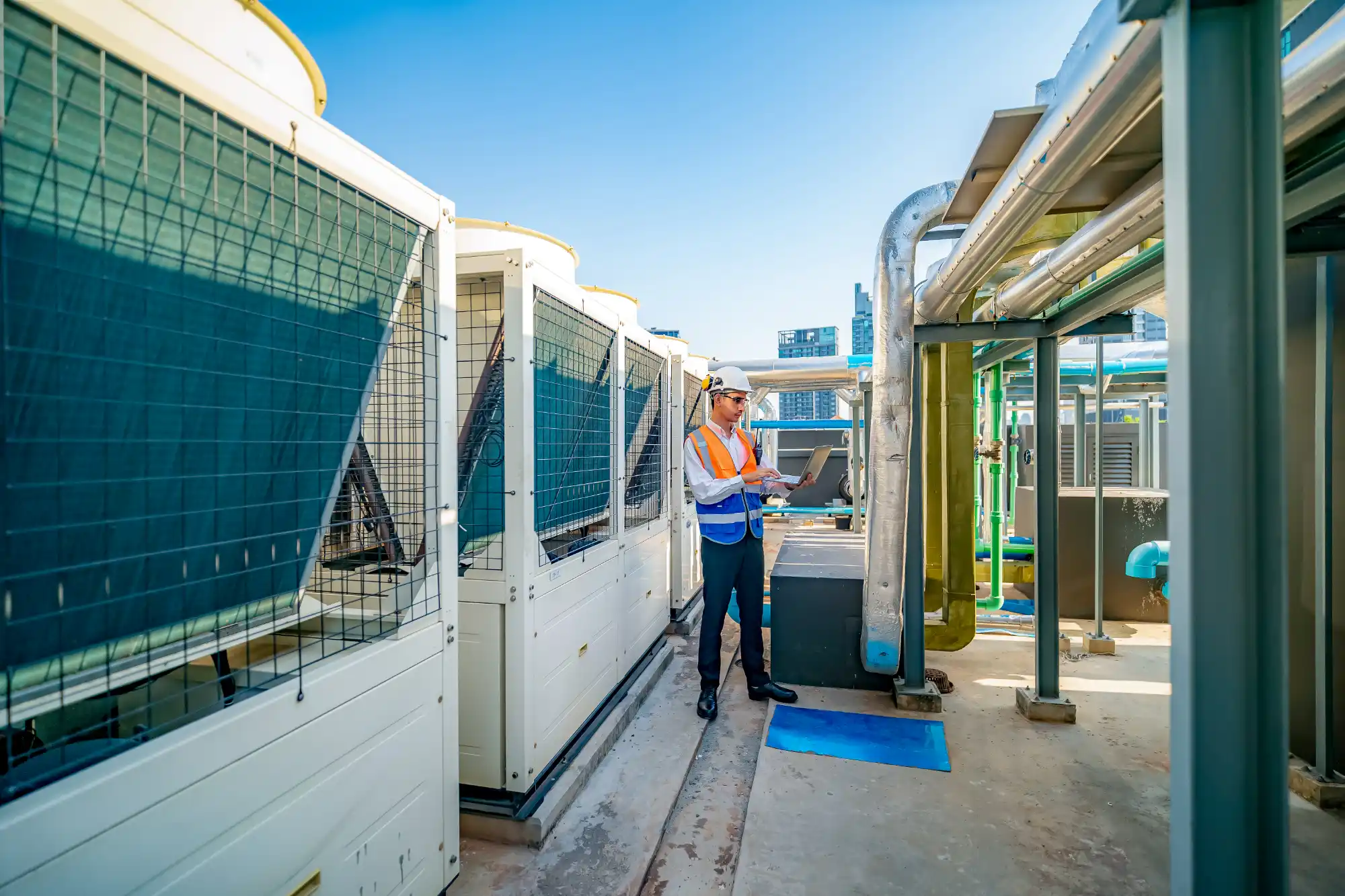 engineer-inspecting-rooftop-hvac-units-with-laptop-sita. SITA technician performing HVAC commissioning on air handling unit in a Central Florida commercial building